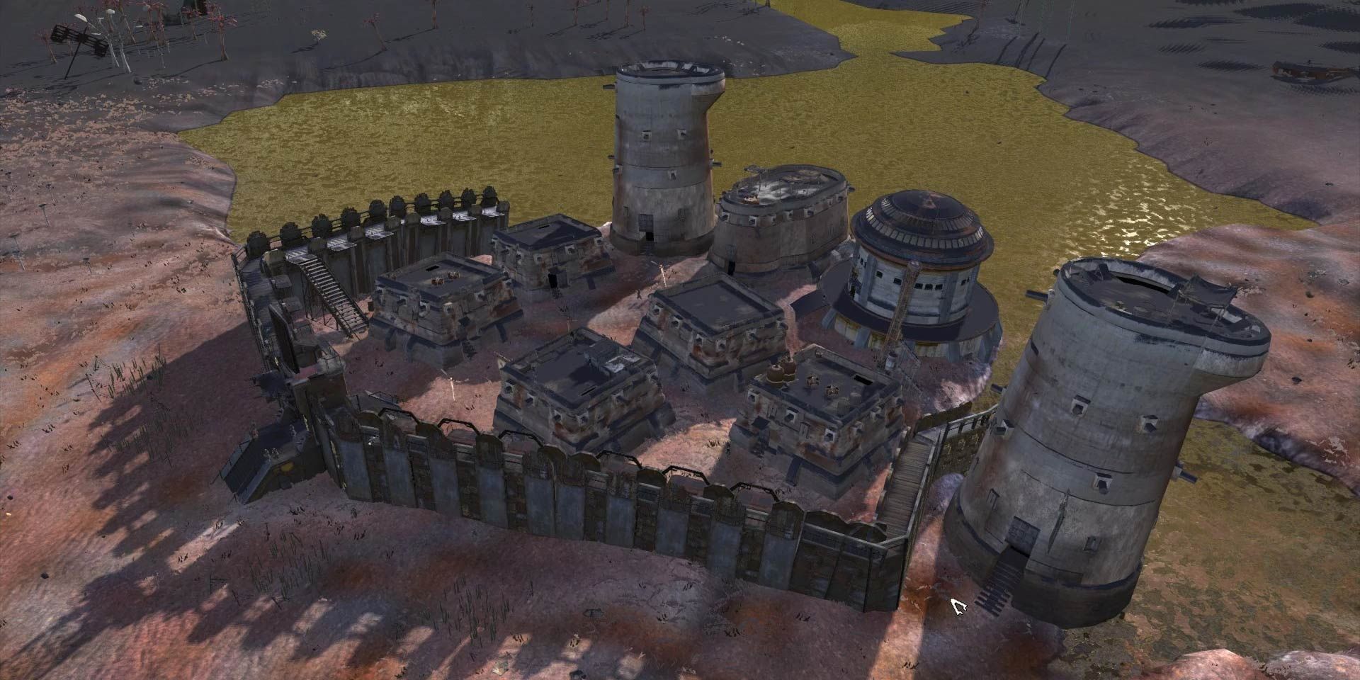 A town in Kenshi by a small pool of brown water, surrounded by guard towers and metal walls.