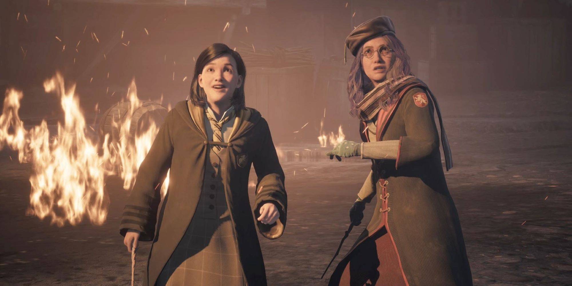 Poppy Sweeting and the Hogwarts Legacy protagonist stand in front of burning barrels.