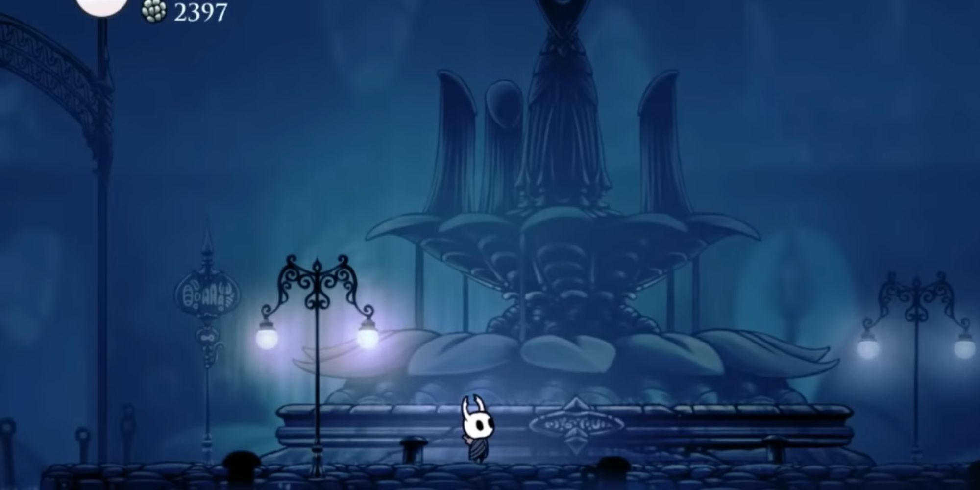 Hollow Knight standing by the fountain in the City of Tears 