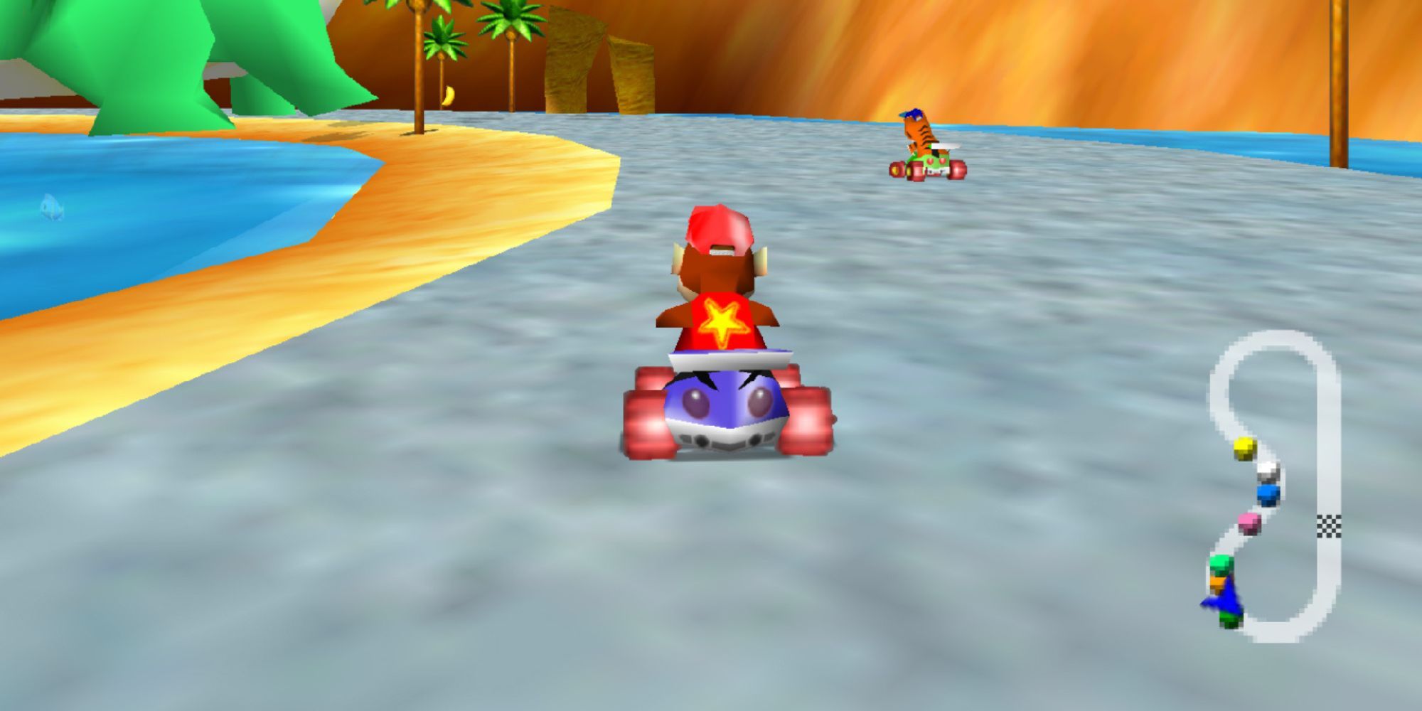 Diddy Kong Racing has Diddy Kong racing a tiger in a blue kart and star on his back along the sandy beach with water on both sides