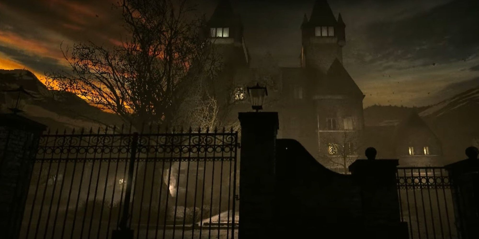 The Outlast character is looking at the asylum from behind the gate while the sun sets behind the building. 