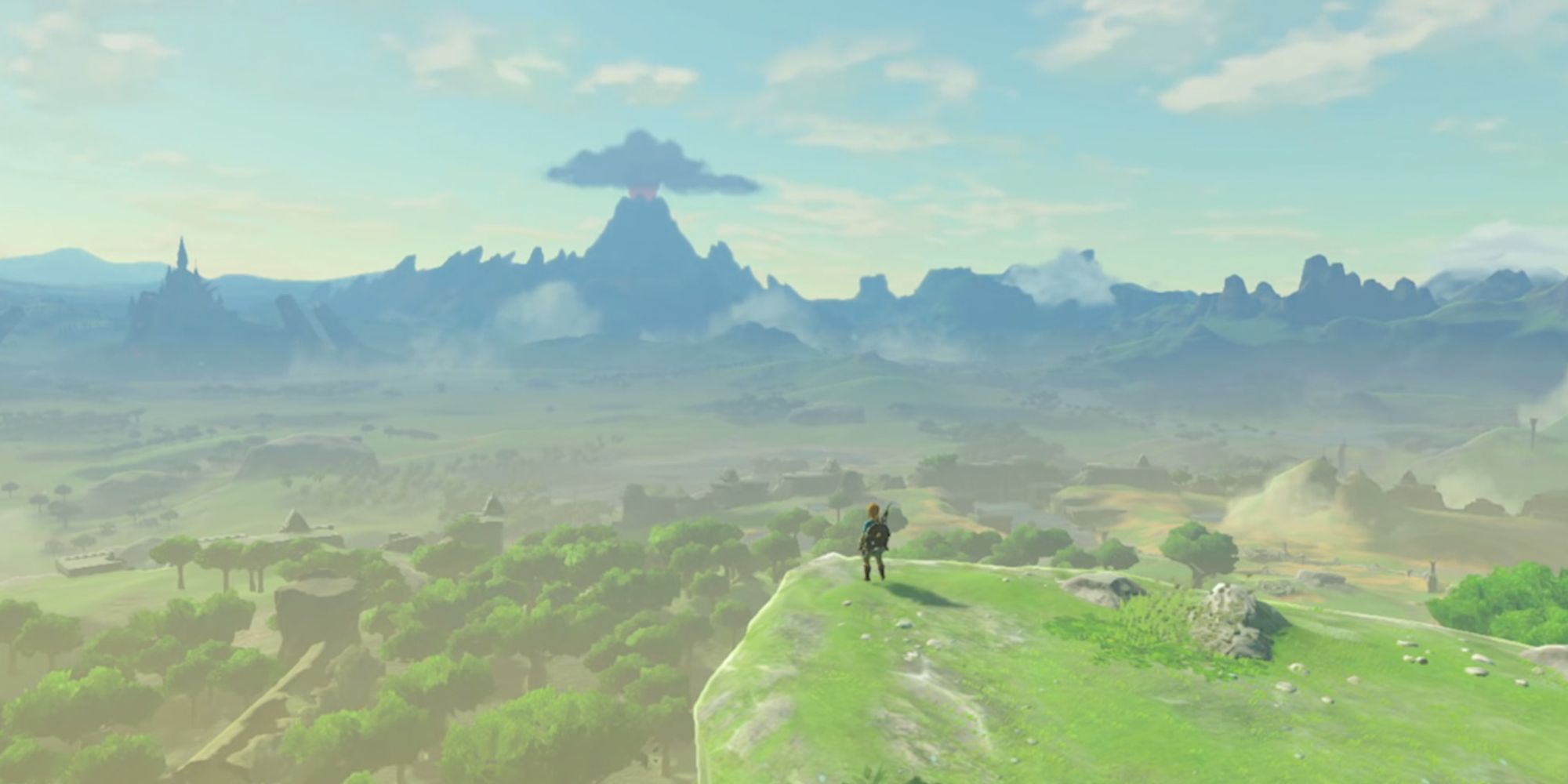 Link stands on a grassy cliff looking over the kingdom of Hyrule in The Legend of Zelda: Breath of the Wild Opening