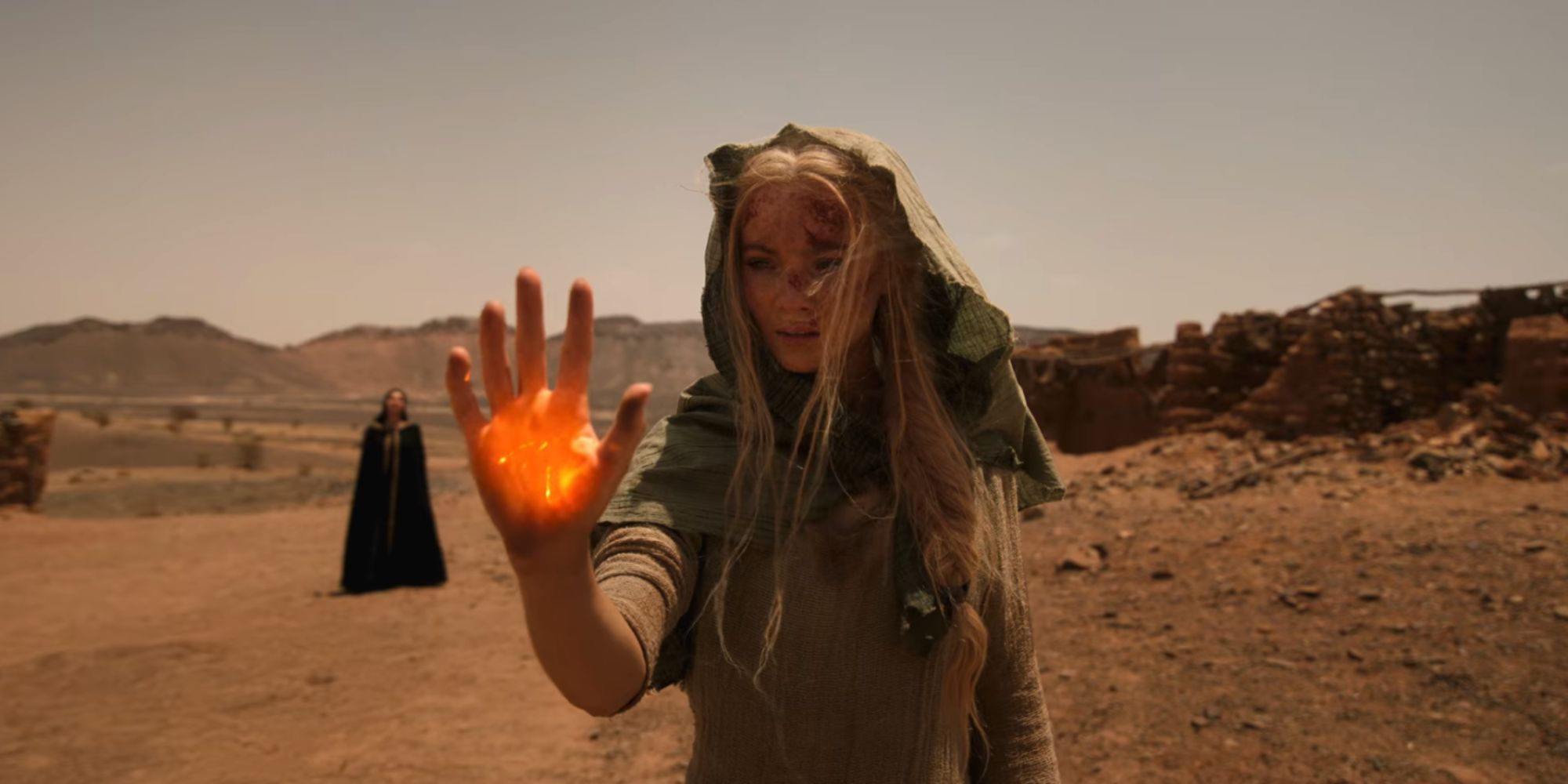 Still of Ciri in the desert summoning fire magic in her hand in The Witcher season 3