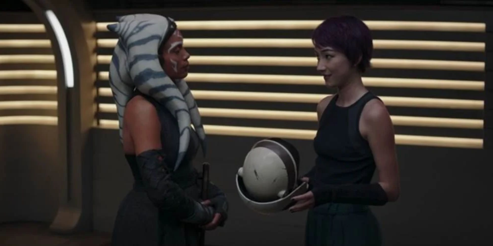 Still of Ahsoka giving Sabine Wren a sparring helmet in Ahsoka