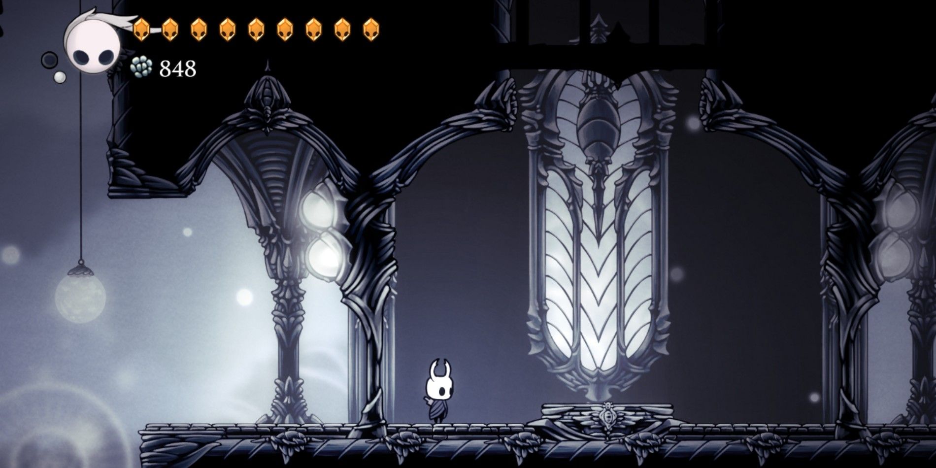 The Knight in Hollow Knight standing near an elevator in the White Palace