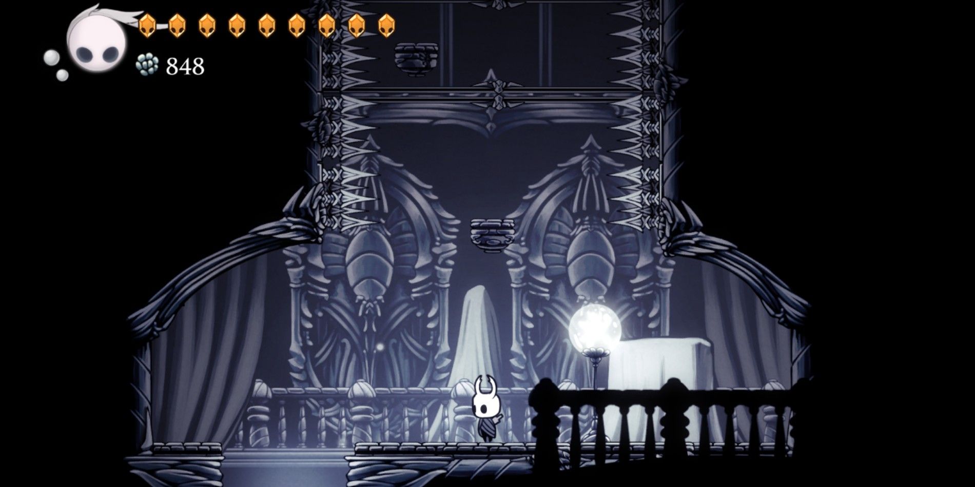 The Knight in Hollow Knight standing in a room in the White Palace with spikes and saws